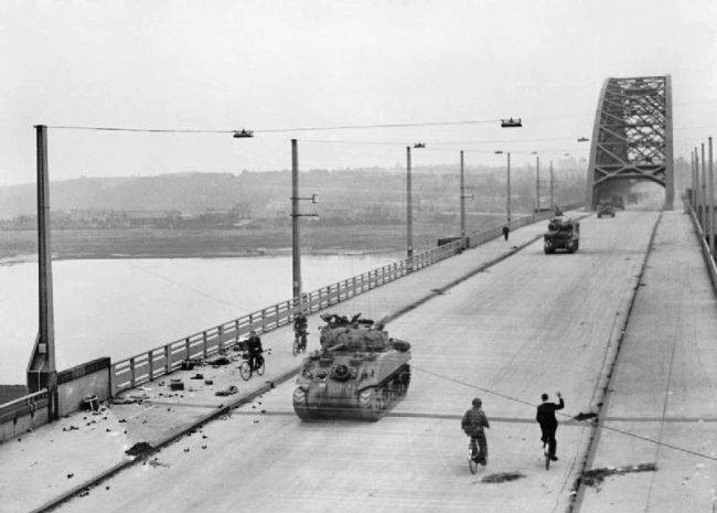 British tanks of XXX Corps cross the road bridge at Nijmegen.